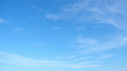 A timelapse of this blue sky captures delicate wisps of white clouds drifting across a bright expanse, symbolizing fair weather, calm conditions, and the gentle flow of atmospheric patterns in motion. - Powered by Adobe