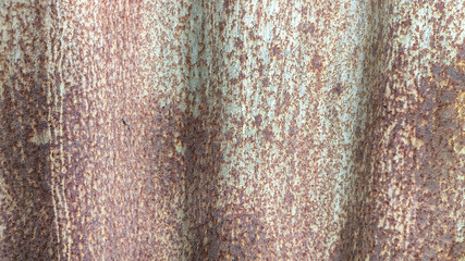 Corrugated zinc fence panel showing signs of oxidation and vintage wear. Rusty metal wall texture great for retro construction visuals, background layers, or aged industrial themes.
