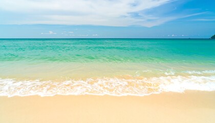 Obraz premium Serene Turquoise Ocean Waves Gently Rolling onto a Golden Sandy Beach Under a Blue Sky.