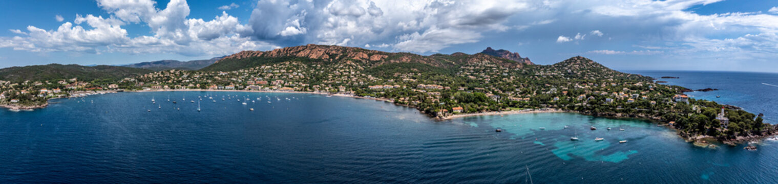 panoramic aerial landscape view of French Riviera coastline along Agay Bay in Saint-Rapha&euml;l with Plage d'Agay and Plage de La Baumette, many boats anchored in bay, wooded hilly landscape in background