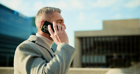 Businessman, discussion and listening with phone call in city for conversation or negotiation. Mature, man or talking with mobile smartphone for business communication, deal or chat in an urban town