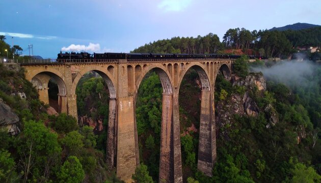 A grand railway bridge of brass and iron stretching across a canyon, with steam