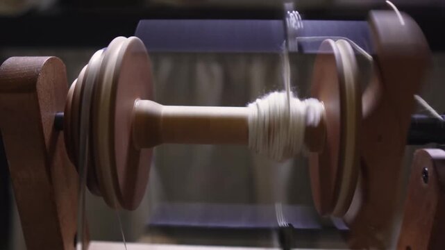 Manual bobbin winding on a spinning wheel
