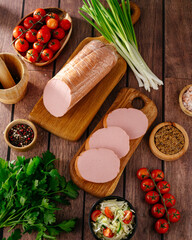 boiled sausage on a wooden plate with green onions © Cavan