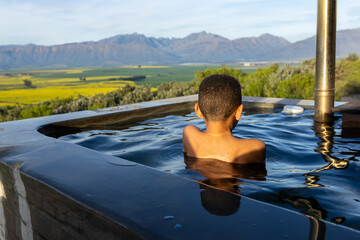 Fototapeta premium Boy in a hot tub with a Mountain View
