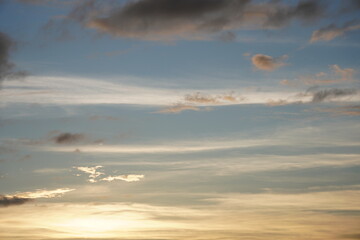 The dramatic sky with orange hue of sunlight, clouds are lining in the sky