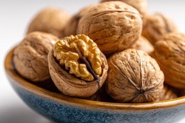A bowl filled with whole  cracked walnuts revealing the edible kernel showcasing their texture  natural color
