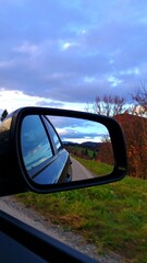 Scenic road view reflected in a car mirror