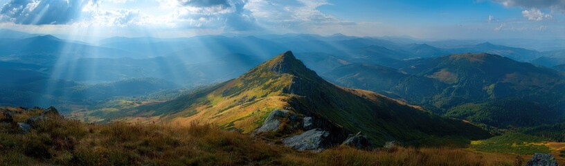 Panoramic mountain vista, sunbeams piercing clouds, hazy atmosphere