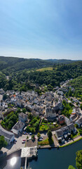 Esch-sur-Sure, Wiltz, Grand-Duche de Luxembourg, August 10, 2025, Aerial view of a picturesque village nestled in greenery by a serene river is stunning and breathtaking