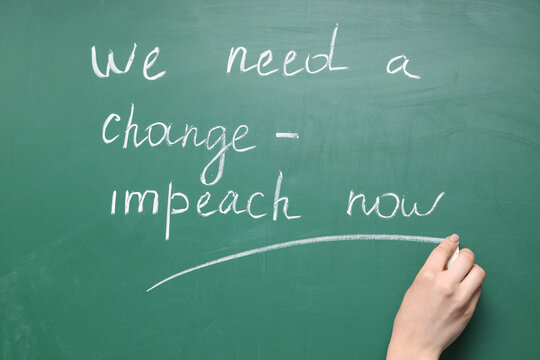 Woman writing text WE NEED A CHANGE - IMPEACHMENT NOW on chalkboard