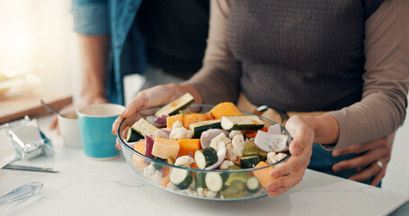 Woman, hands or bowl with vegetables in kitchen for meal prep, salad or healthy food at home. Closeup, female person or couple with vegetarian recipe or ingredients for natural organic snack in house