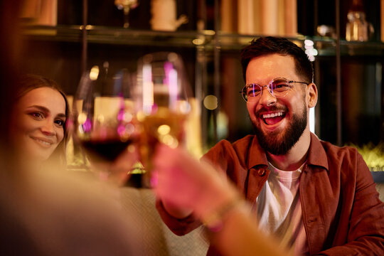 Friends Enjoying Drinks and Laughing Together in a Stylish Bar Setting