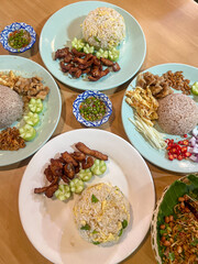 Close up shot of Thai shrimp paste fried rice with shallot, sweet barbeque pork, fried egg, vegetable and spicy chili.