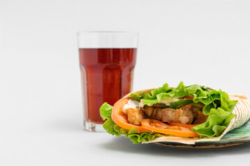 Tasty doner kebab and drink on light background