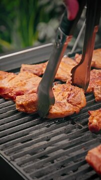 Close-up of raw marinated pork ribs placed on a barbecue grill, ready for cooking over hot charcoal.