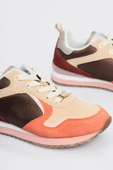 Brown women's suede leather sneakers isolated on white background. Sports basketball shoes, boots for female. Footwear, casual leather training, gym, fitness shoes. Template, mock up. Close up, detail