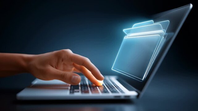 Hand typing on laptop keyboard with digital folder appearing above screen. Dark background enhances focus on technology and productivity