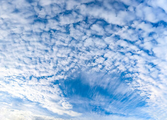 Obraz premium A fan of cirrus clouds unfolds against a blue sky. A panoramic view of a wide-angle landscape. An all-encompassing impression of endless possibilities, freedom flight.