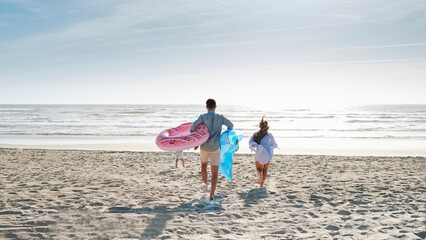 Man and woman enjoying with son at beach on sunny day
