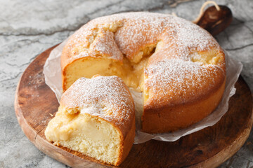 Italian Custard Cake or Torta Nua is a soft Italian cake baked with dollops of Italian pastry cream closeup on the wooden board on the table. Horizontal