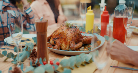 People, chicken and dining with friends for thanksgiving, social gathering or hospitality. Group, community or BBQ with roasted recipe for catering service, festive meal or holiday dinner at table