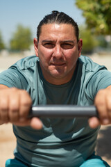 Mid adult man using outdoor gym equipment for his workout routine
