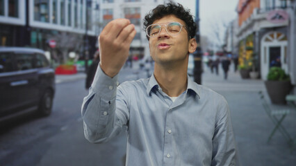 Young hispanic man gestures finger to lips for silence on busy city street with blurred pedestrians and taxi in frame; quiet mystery.