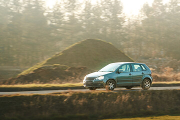 Fototapeta premium Black car traveling on empty country road