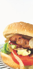 Close up. Hamburger with its typical bread, lettuce, tomato and onion. Vertical shot.	