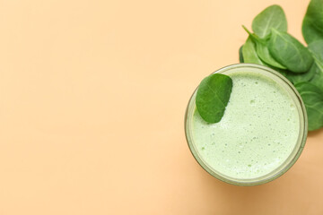 Glass of fresh spinach smoothie on yellow background