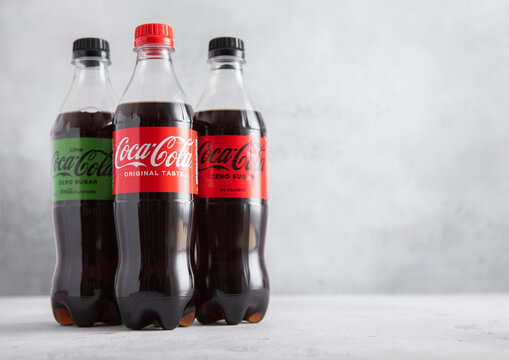 LONDON,UK - JUNE 13,2025: Bottles of Original Coca Cola with cola zero sugar and lime taste cola on light table background.