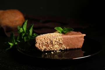Plate with tasty cheesecake pop on black background