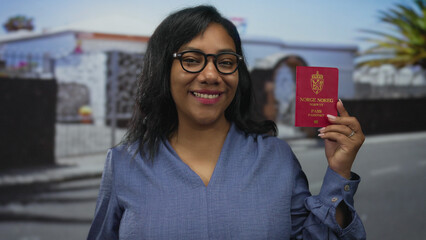 Woman holds norwegian passport with a smile on street lined with palm trees during daytime; travel...