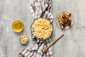 Napkin, nuts and bowl with cornflakes on grunge background