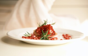 Delicious raw vegan dessert with fresh pomegranate seeds and rosemary, perfect for natural, healthy, and clean eating lifestyles.
