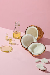 A vertical composition with coconut pieces and oil bottle under soft light, perfect for beauty and organic skincare concepts. Space for design