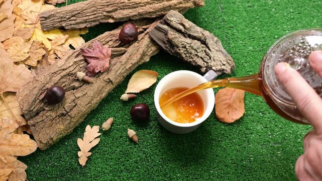 Versare bevanda calda nella tazza, ambientazione autunnale