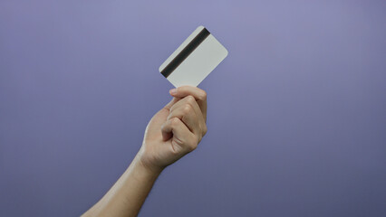 Man holding credit card with purple background showcasing financial concept in an isolated setting highlighting identity and payment themes.