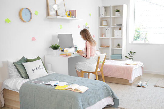 Female student studying at table in dorm room