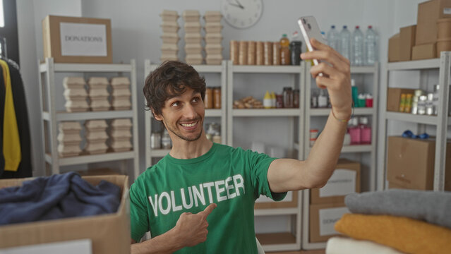 Man holds smartphone for selfie and points finger to chest in donation center building; pride service.