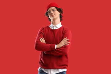 Fashionable young man in red clothes on color background
