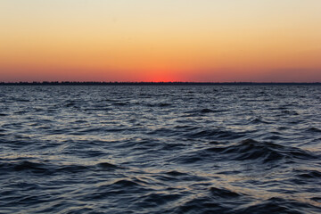 sunset on the seashore, estuary, sun rays on the water