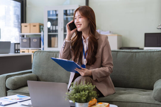 Business woman Asian talking phones update plan working on laptop computers, online business.