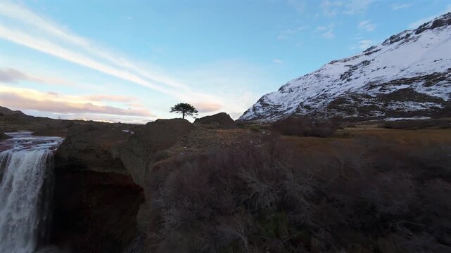 Amazing dynamic drone movement into the Agrio Waterfall aka Salto Del Agrio in snowy Patagonian mountains, Caviahue, Neuqu&eacute;n, Argentina.
