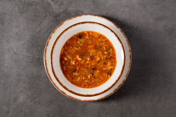 Hot and sour Asian soup with vegetables in white bowl
