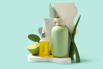 Composition with different natural cosmetic products, lime, eucalyptus and aloe vera leaves on turquoise background