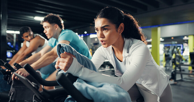 Fitness, spin class and people in gym on bicycle for cardio exercise, workout and training. Sports machine, health club and woman on stationary bike for cycling, endurance and challenge for wellness - Powered by Adobe