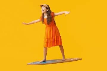 Cute girl on surfboard against yellow background