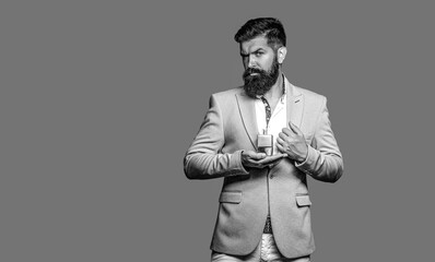 Masculine perfumes. Man in suit, bottle of perfume, closeup. Man sprays perfume on himself. Man holding a bottle of perfume. Man holding bottle of perfume, smells, fragrance. Black and white